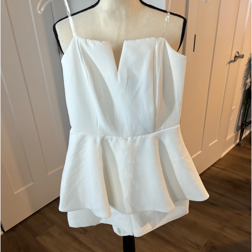 Strapless, short jumpsuit.  V-neck bust. Back zip with a flounce layer at waist